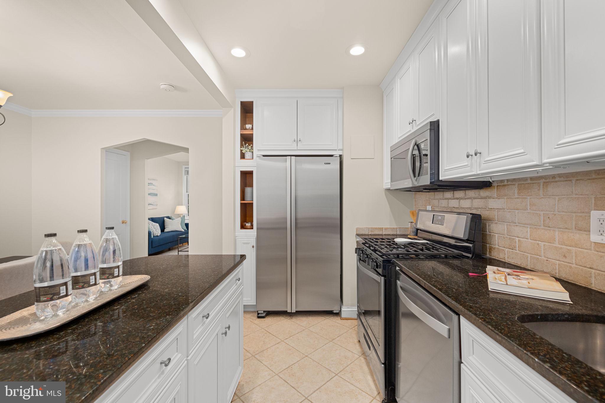 3762 W Street Northwest Washington, DC 20007 - Photo 14 of 41 a kitchen with stainless steel appliances granite countertop a sink stove and refrigerator