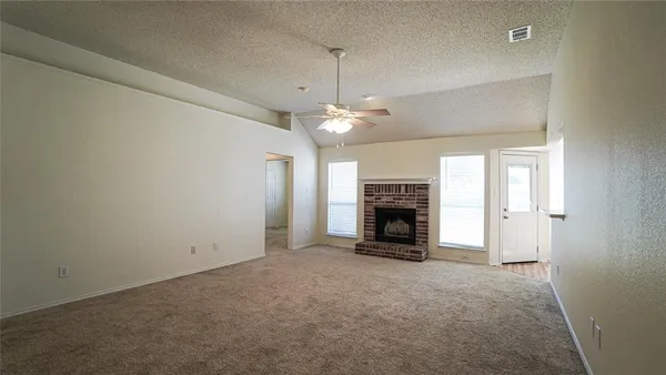 an empty room with fireplace and windows
