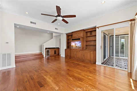 a view of a livingroom with wooden floor and a ceiling fan