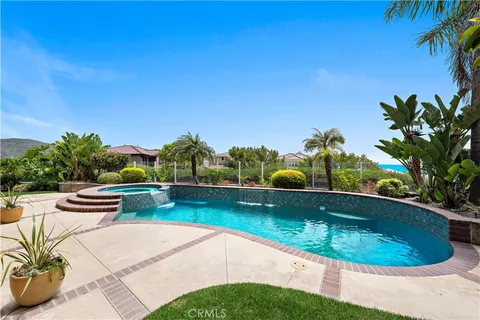 a view of a swimming pool with a yard and plants