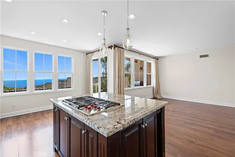 a kitchen with a stove and a wooden floor