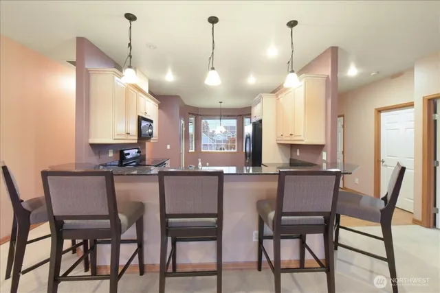 a kitchen with a dining table chairs and cabinets
