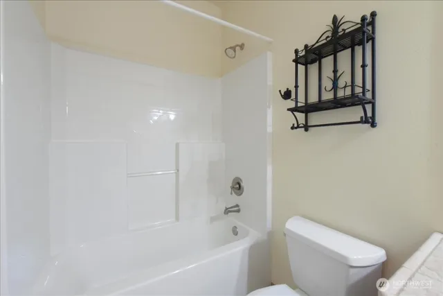 a white toilet sitting next to a bath tub