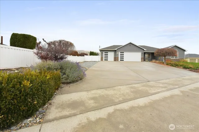 a view of a house with a yard and large trees