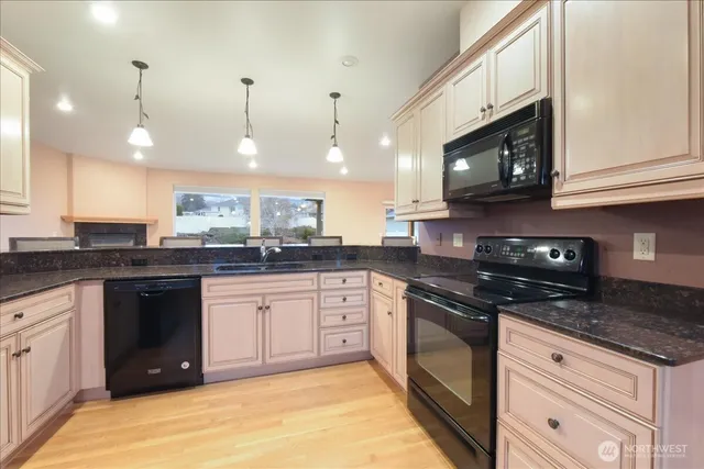 a kitchen with stainless steel appliances granite countertop a stove a sink and a microwave