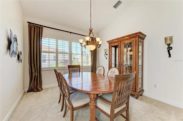 a kitchen with stainless steel appliances granite countertop a stove a sink dishwasher a dining table and chairs with wooden floor