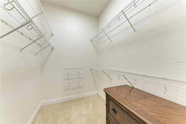 a bedroom with a bed and a dresser next to a window