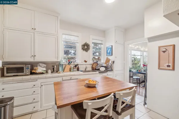a very nice looking living room with stainless steel appliances furniture a rug and a view of kitchen