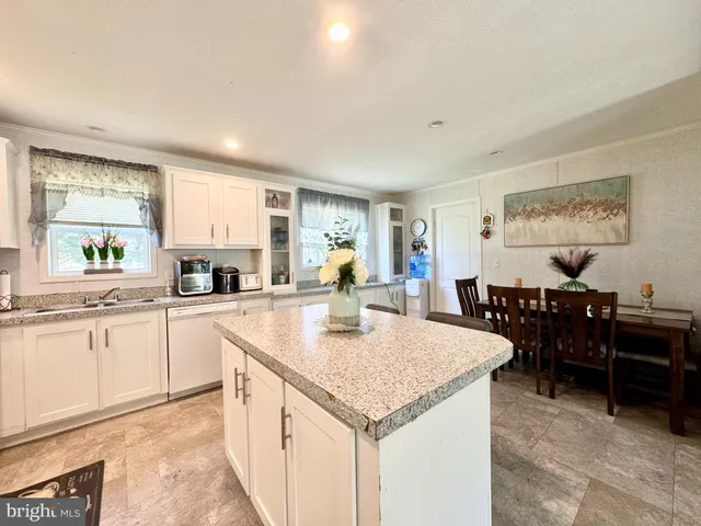 a large kitchen with kitchen island a sink table and chairs