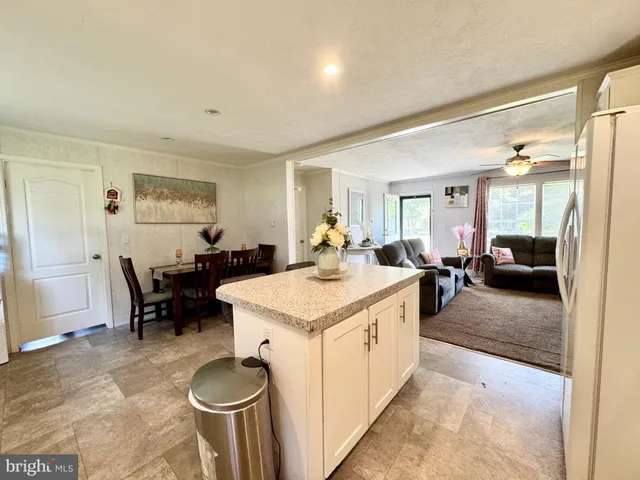 a large living room with stainless steel appliances granite countertop furniture a couch and a view of living room