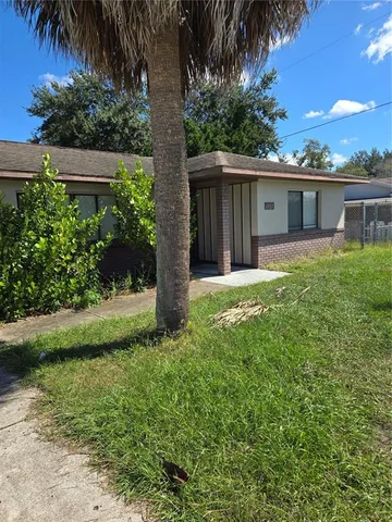 a view of a house with a yard and potted plants
