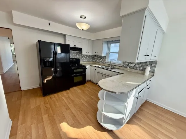 a kitchen with stainless steel appliances granite countertop a sink a stove a refrigerator and island