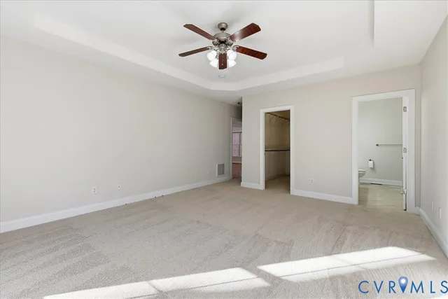 an empty room with closet and a ceiling fan
