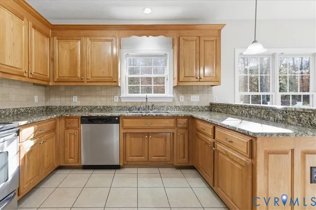 a kitchen with granite countertop a sink window and cabinets