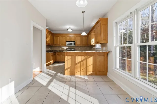a kitchen with kitchen island granite countertop a stove a sink and a microwave