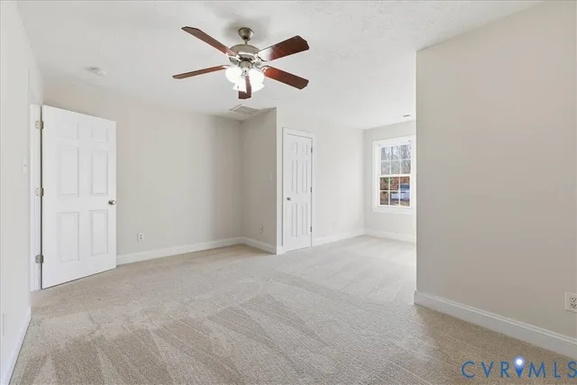 an empty room with chandelier fan