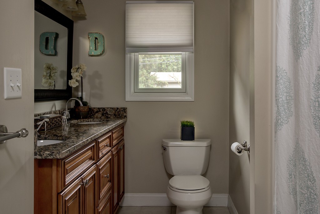 12 Amy Road Framingham, MA 01701 - Photo 21 of 30 a bathroom with a granite countertop toilet a sink and a mirror