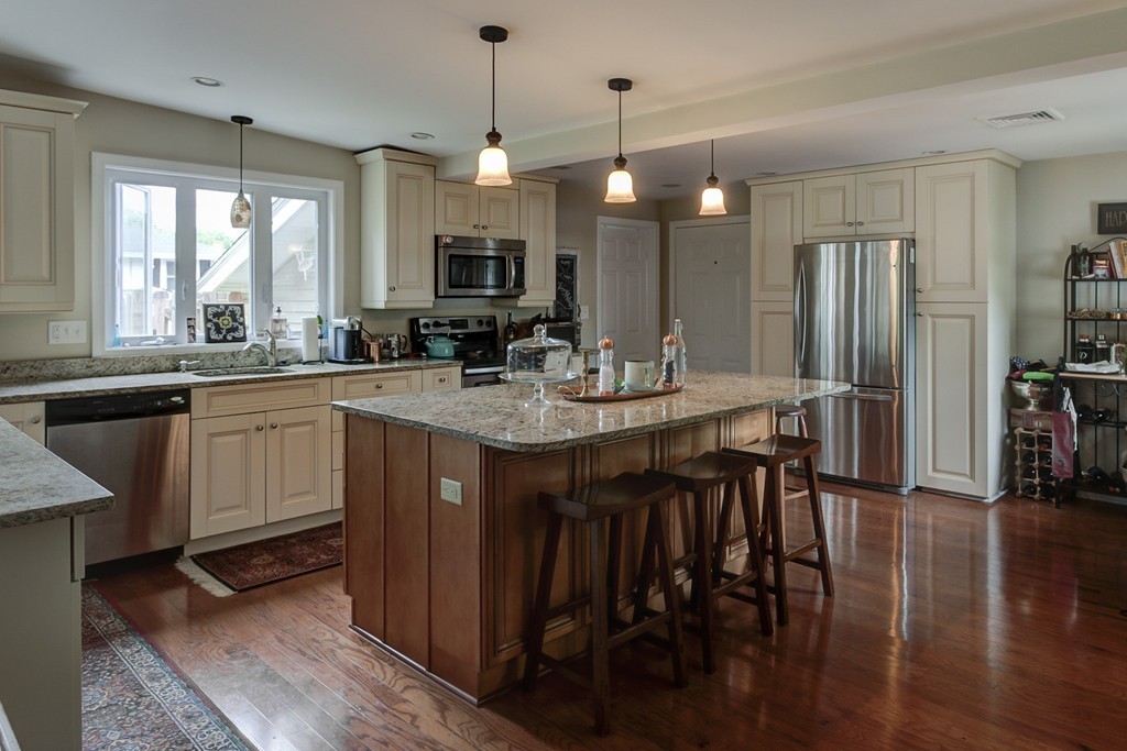 12 Amy Road Framingham, MA 01701 - Photo 3 of 30 a kitchen with a sink stove and wooden floor