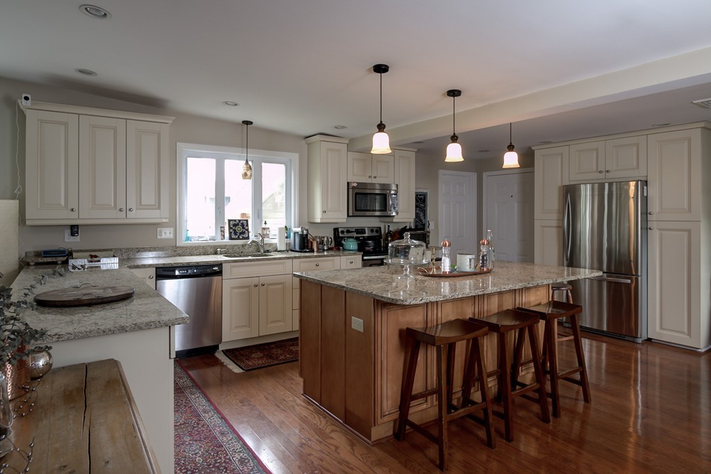 12 Amy Road Framingham, MA 01701 - Photo 4 of 30 a kitchen with kitchen island granite countertop a sink a counter space appliances and cabinets