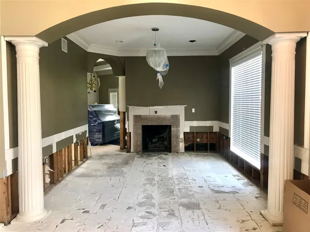 a view of a livingroom with a fireplace cabinet and windows