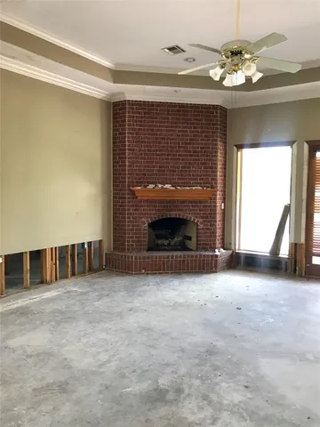 a view of an empty room with a fireplace and a window