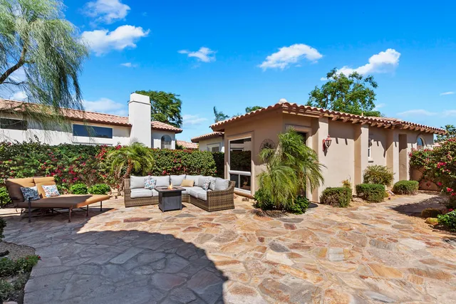 a view of a chair and tables in the patio in front of a house
