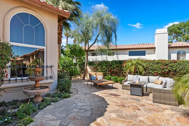 a living room with furniture a fireplace and a floor to ceiling window