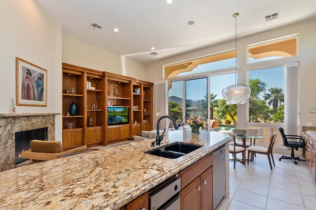 a kitchen with stainless steel appliances granite countertop a stove refrigerator and a sink