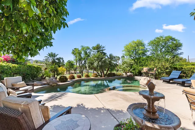 a swimming pool with outdoor seating and yard