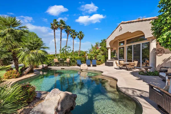 a view of a patio with couches table and chairs with potted plants