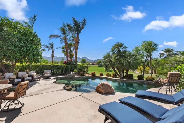 a view of backyard with swimming pool and outdoor seating