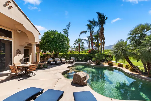 a view of a house with swimming pool and sitting area