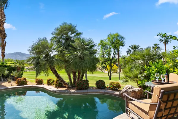 a view of a house with swimming pool and sitting area
