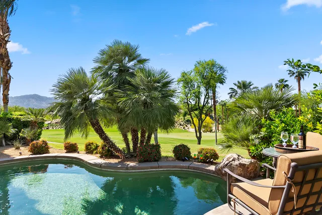 a view of a house with swimming pool and sitting area