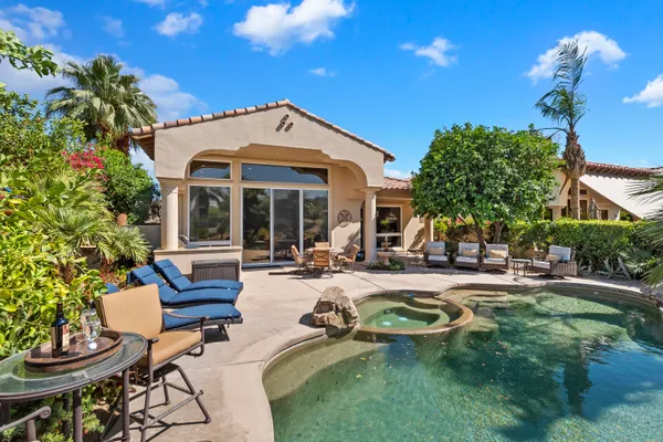 a view of a house with swimming pool and sitting area