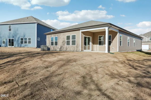 a view of a house with a big yard and large tree