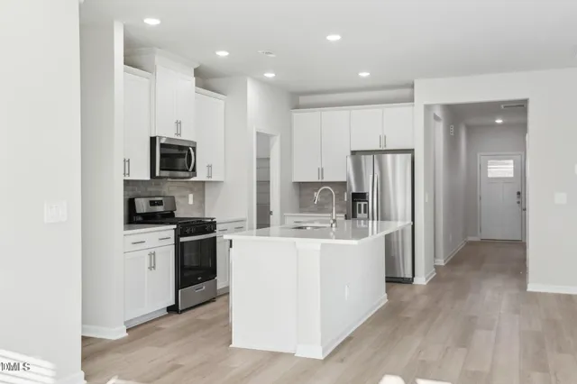 a view of kitchen with wooden floor and electronic appliances