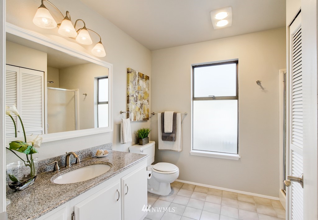 555 Prospect Street, Unit 3 Seattle, WA 98109 - Photo 20 of 23 a bathroom with a granite countertop sink toilet and mirror
