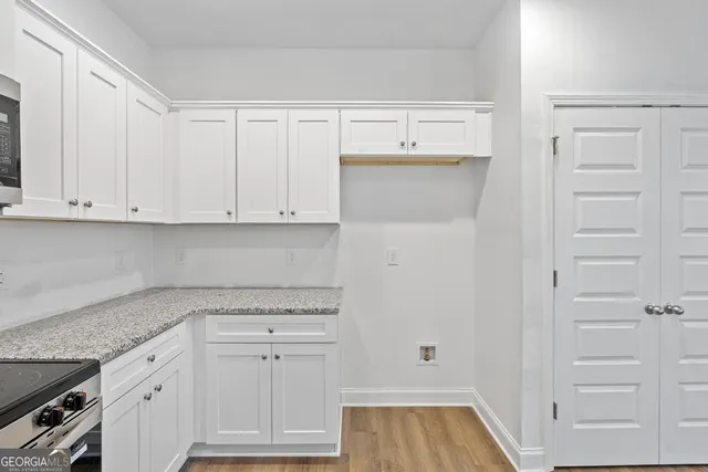a kitchen with white cabinets and white appliances