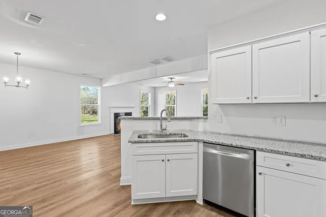 a kitchen with granite countertop white cabinets and white appliances