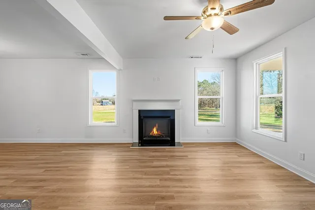 a view of an empty room with a window and fireplace