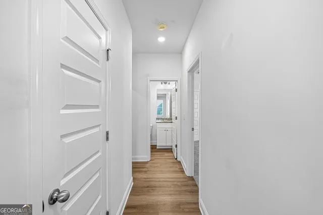 a view of a hallway with wooden floor and closet