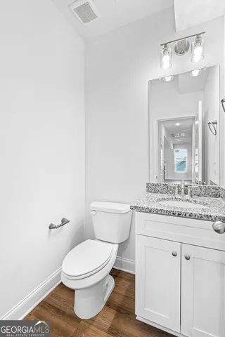 a bathroom with a granite countertop toilet sink and mirror