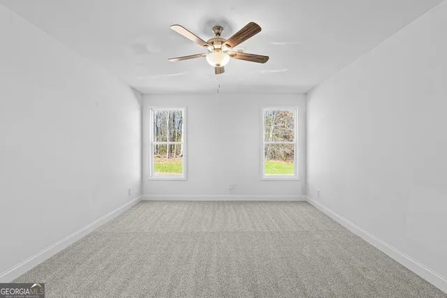 an empty room with window and ceiling fan