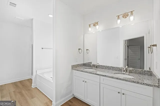 a bathroom with a granite countertop sink and a mirror