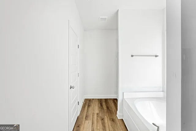 a view of a bedroom with wooden floor