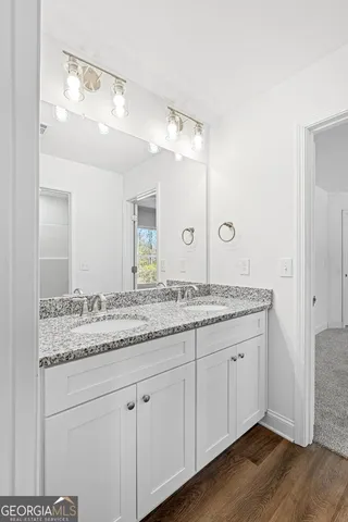 a bathroom with a granite countertop sink and a mirror