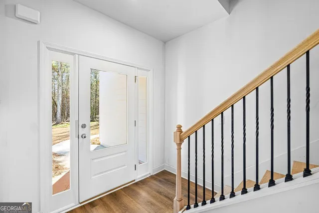 a view of a hallway with wooden floor and staircase
