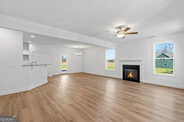 a view of empty room with wooden floor and fireplace