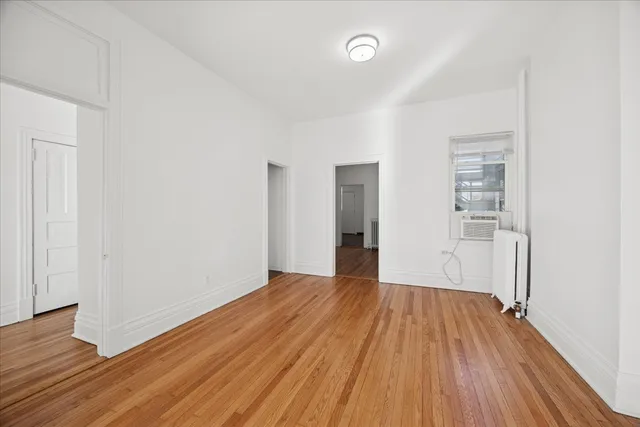 a view of a big room with wooden floor and windows